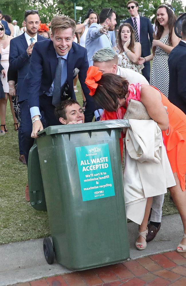 Actual photo caption provided by Getty Images: “A man is pushed into a rubbish bin following 2016 Melbourne Cup Day at Flemington Racecourse on November 1, 2016 in Melbourne, Australia.” Picture: Scott Barbour/Getty Images