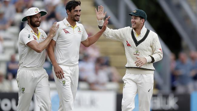 Mitchell Starc, centre, celebrates with Tim Paine, right, and Michael Neser after taking the wicket of Josh Dell of Worcestershire. Picture: Getty Images