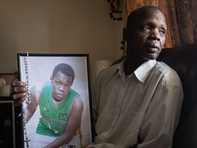 Deng Atem father of Lino and Atom. Lino Atem, 24 (in picture frame), who was stabbed to death near a children's playground in Wyndham Vale on January 10. , The brother of Lino has his hands pictured which were injured in the attack., The family have also been grieving the loss of their eldest son, Atem Atem, who was shot and killed in the family's garage in February 2023. Picture: Jason Edwards