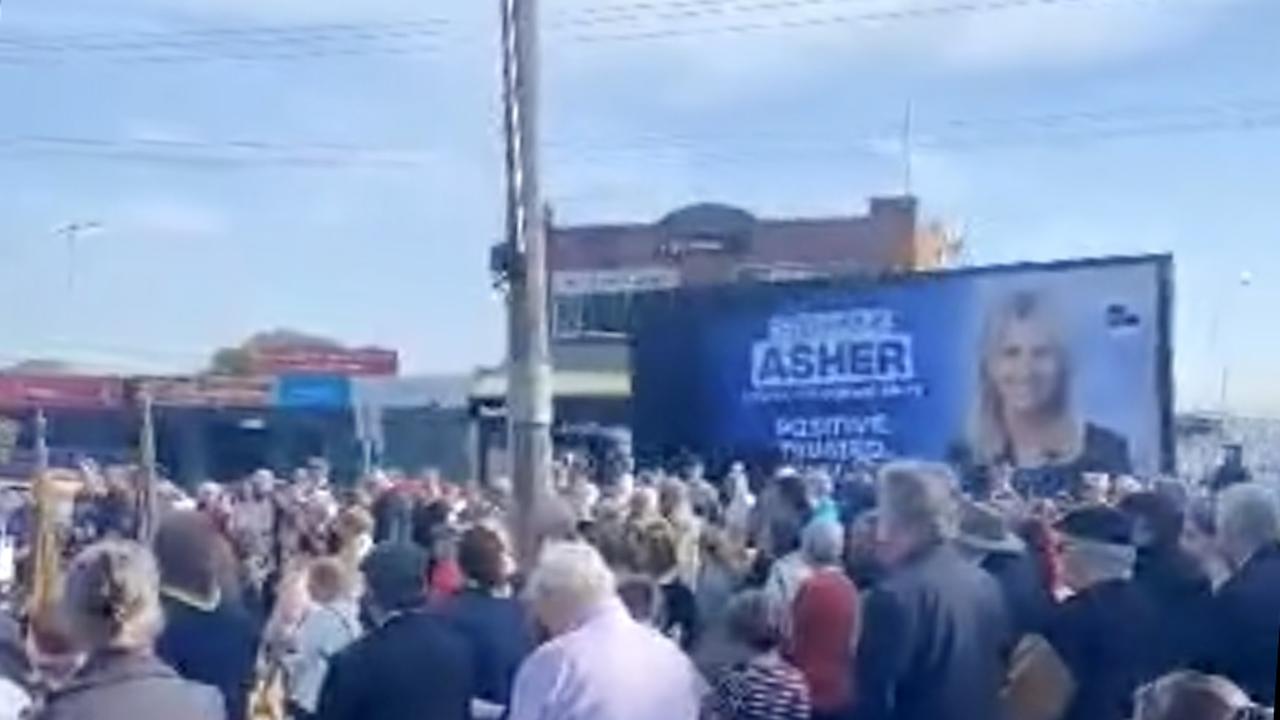 Stephanie Asher billboard drives past an Anzac Day service. Picture: Supplied