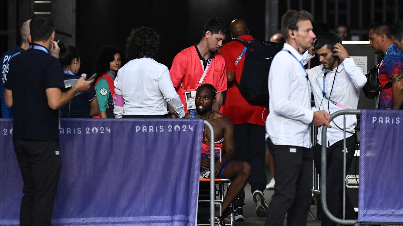 Bronze medallist US' Noah Lyles (C) receives medical attention after competing in the men's 200m final of the athletics event at the Paris 2024 Olympic Games at Stade de France in Saint-Denis, north of Paris, on August 8, 2024. (Photo by Ben STANSALL / AFP)