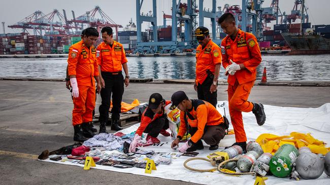 Search and Rescue personnel examine recovered personal items from Lion Air flight JT 610. Picture: Getty