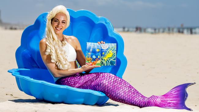 Sandy the Mermaid (Alyce Hill) with children’s book <i>Sandy’s Surfers Paradise Adventure</i>. Photo: Jerad Williams