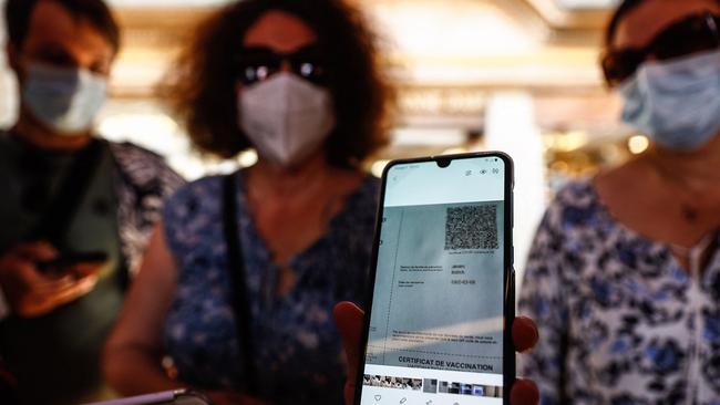 A woman shows her health pass as she arrives at a restaurant in Mont-Saint-Michel, in Normandy, northwestern France. Picture: AFP