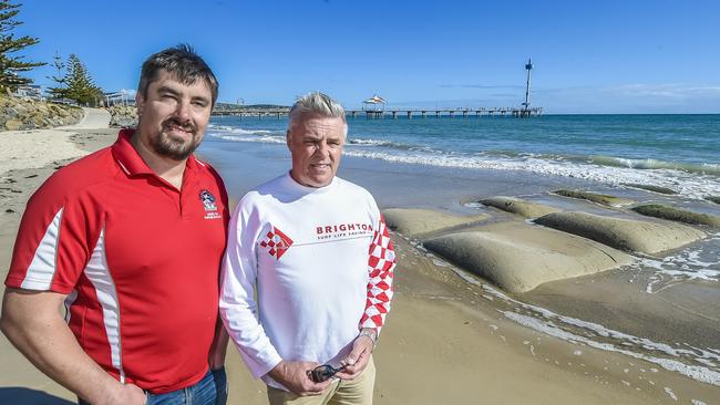 Brighton Surf Life Saving Club president Chris Parsons with volunteer Billy Jackson at one of the existing groynes. Mr Parsons is “not convinced” the groynes are the best solution to the ongoing issues with sand drift. Picture: AAP/Roy Vandervegt