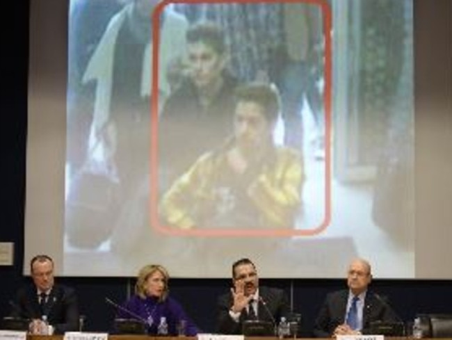 Interpol officials sit in front of CCTV images of the Iranian passengers travelling on MH370 on fake passports. Picture: AFP