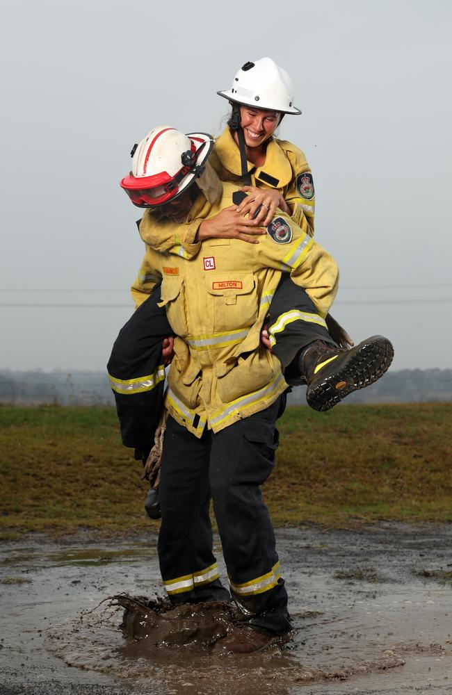 Milton RFS volunteers Glenn Patterson and Tess Oss-Emer celebrating as the rain starts to fall in Milton on Thursday after six weeks of fighting fires. Picture: Jonathan Ng