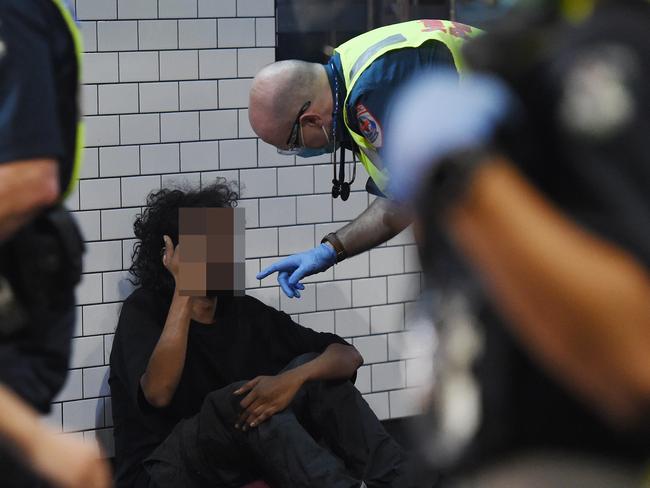 Ride along with ambulance Victoria paramedics responding to call outs for patients most likely to assault or attack them. Ambulance paramedics treat a homeless man who was assulted on Swanston Street. Picture: Josie Hayden