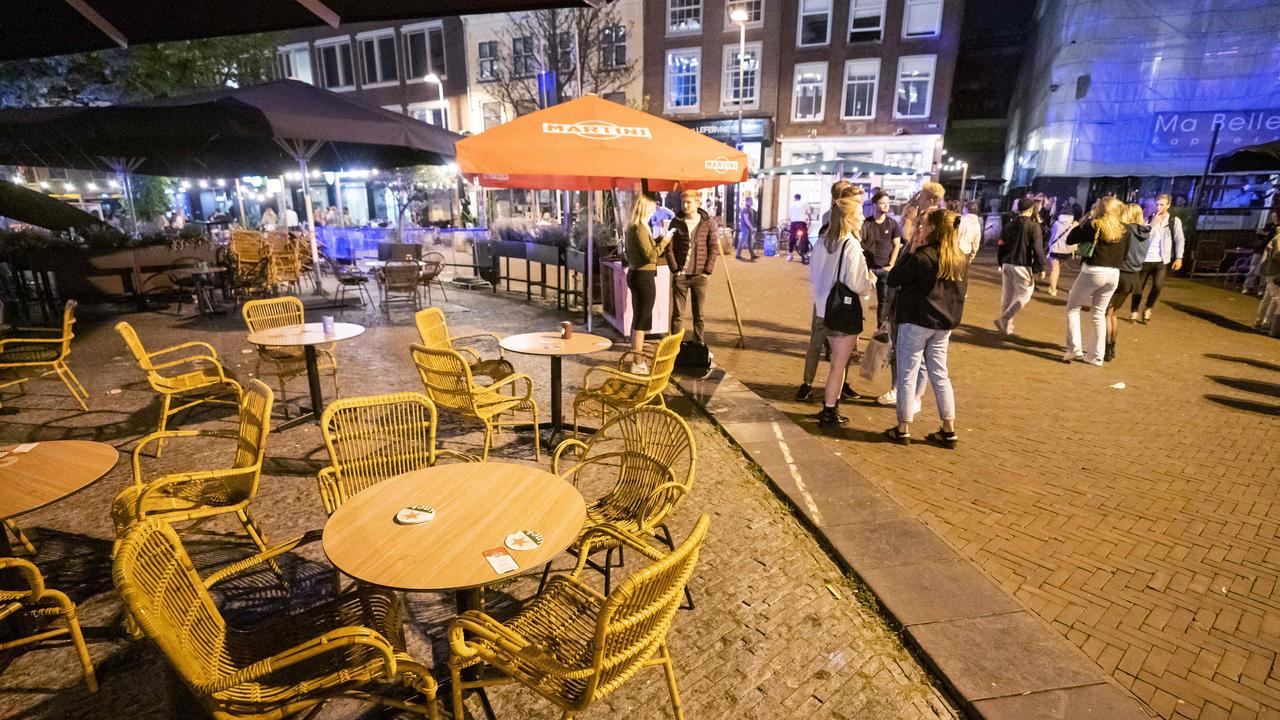 People leave a Dutch cafe in Utrecht last week as a new curfew comes in to fight the Delta strain. Picture: Jeroen Jumulet/AFP