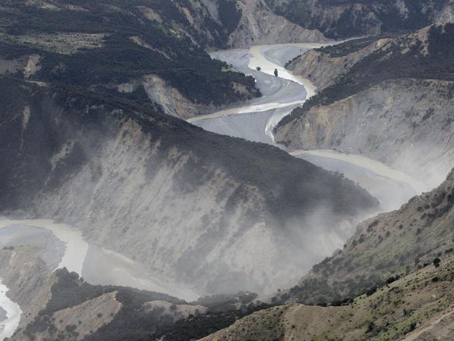 Dust created by a strong aftershock hangs above the Clarence River which was blocked, causing a huge dam, north of Kaikoura. Picture: Mark Mitchell/Getty Images.