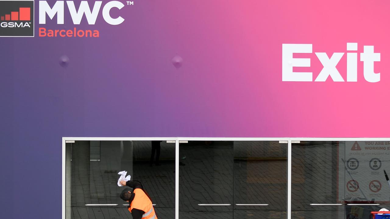 A worker cleans glass doors at the Mobile World Congress venue that will no longer be used to host the since cancelled conference. Picture: Lluis Gene/AFP