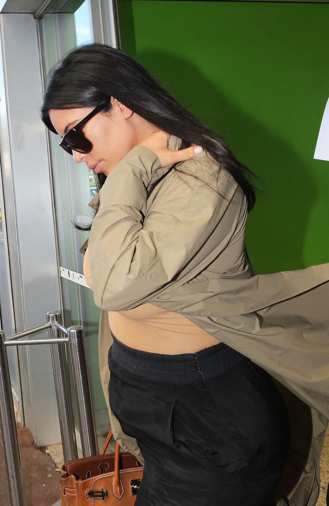 Kim Kardashian’s high-waisted pants revealed her growing baby bump.