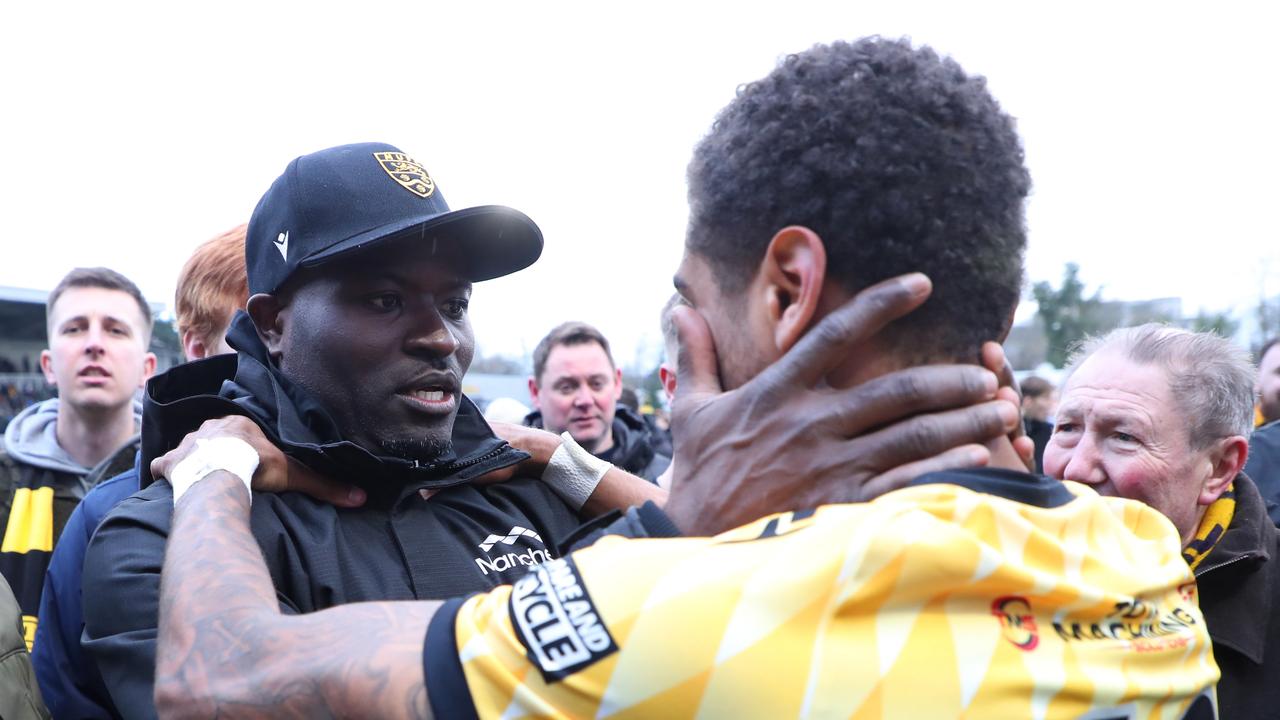 George Elokobi, Manager of Maidstone United, interacts with Liam Sole at full time.