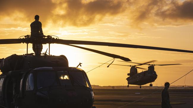 US Army aircrew watch an Australian Army Boeing CH-47 Chinook helicopter land from their UH-60M Blackhawk helicopter during Exercise Talisman Sabre.