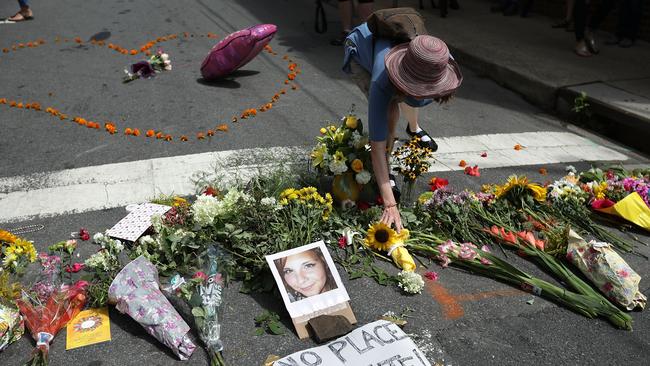 A woman places flowers at an informal memorial to 32-year-old Heather Heyer, who was killed when a car ploughed d into a crowd of people protesting against the white supremacist Unite the Right rally. Picture: AFP