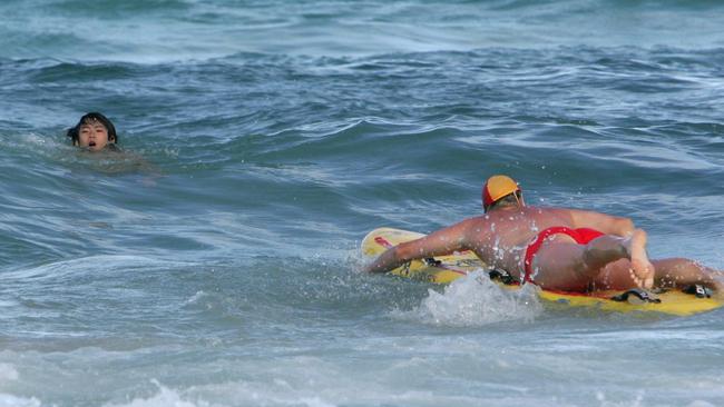 Wayne Heneker rushes out to save a young Japanese boy in distress at Surfers Paradise.