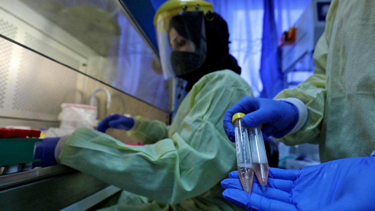 A medical worker handles test samples. Picture: Abbas Momani / AFP