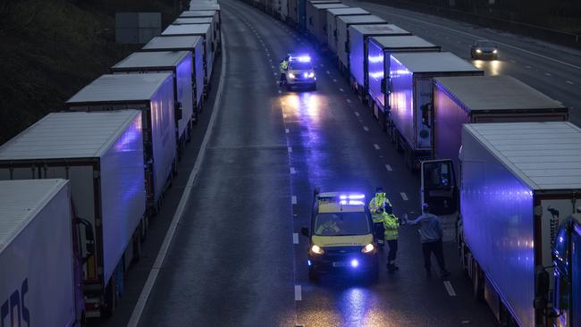 Coastguard officers give bottles of water to truck drivers stuck on the M20 at Sellinge, England, after France closed its border with Britain. Picture: Getty Images