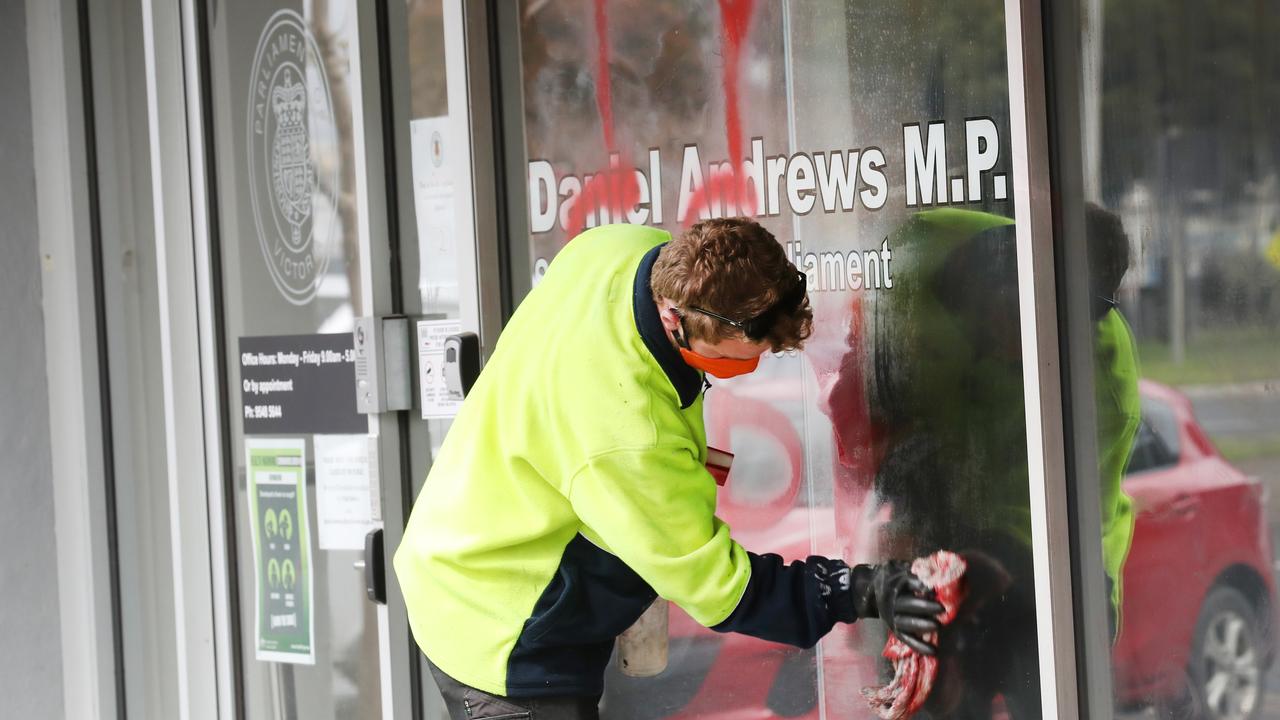 A cleaner removes paint from a window at Mr Andrews’s office on September 25. Picture: David Crosling