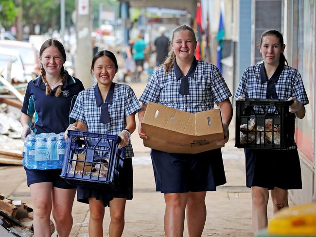 Summerland Christian College students Lani Blunn Sophia Su Saffron Anderson and Sophia Alvarez deliver food and water to people in Molesworth St on March 4 last year. Picture: Toby Zerna