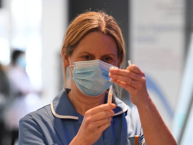 A healthcare professional draws up a dose of AstraZeneca/Oxford Covid-19 vaccine in a syringe at the vaccination centre set up at Chester Racecourse, in Chester, northwest England, on February 15, 2021. - Prime Minister Boris Johnson on February 14 called Britain hitting a target of inoculating 15 million of the most vulnerable people with a first coronavirus jab "a significant milestone", as the country prepared for the next phase of its vaccination programme. (Photo by Oli SCARFF / AFP)