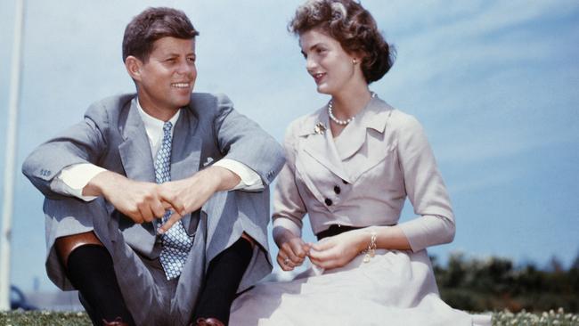 John F. Kennedy and Jacqueline Bouvier sit together in the sunshine at Kennedy's family home at Hyannis Port, Massachusetts, a few months before their wedding.