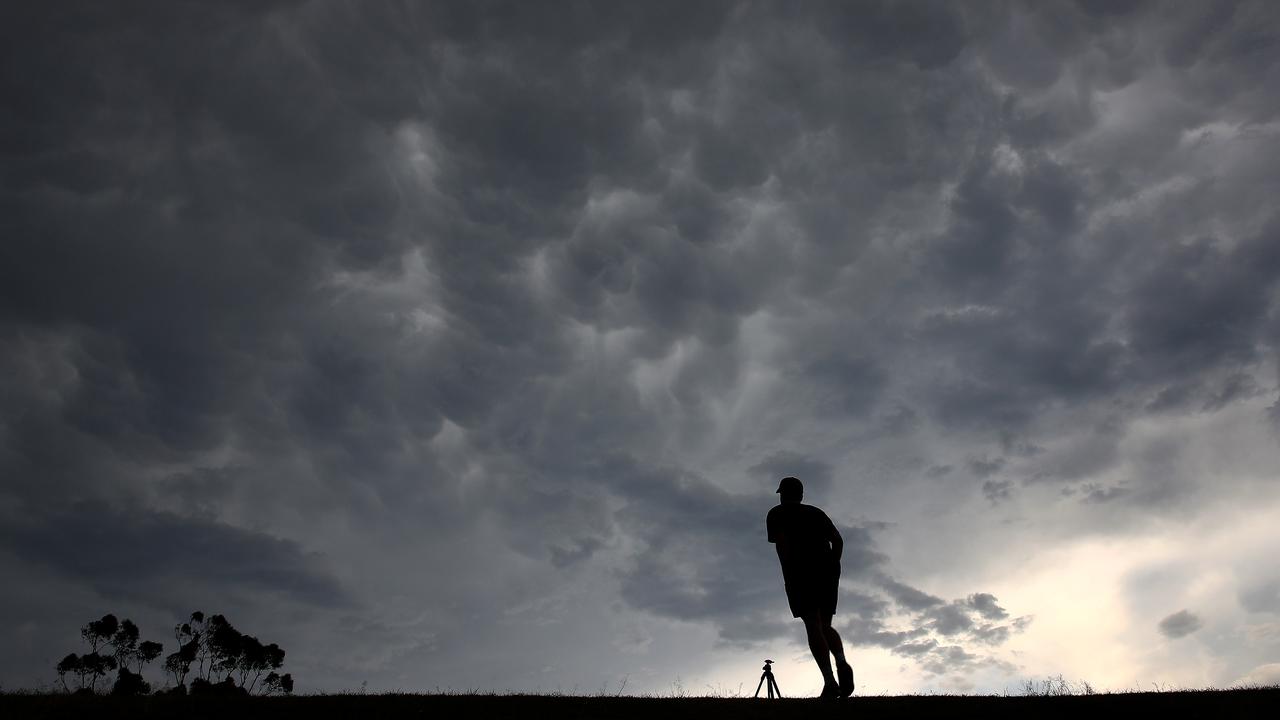 Storm clouds gathered over Sydney late this afternoon. A jogger runs up the hill at Moore Park golf course ahead of the approaching storm. Picture: Toby Zerna