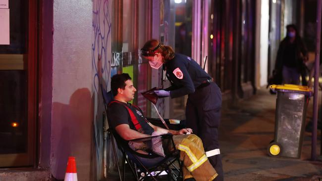 A paramedic treats a firefighters at the scene. Picture: David Crosling