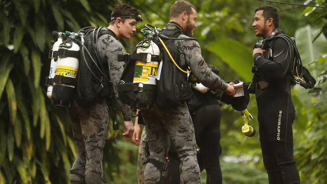 Australian Federal Police and Defence Force personnel talk with a Thai diver after the 12 boys and their soccer coach were found alive in a flooded cave in Mae Sai, Chiang Rai province, northern Thailand. Picture: Sakchai Lalit/AP