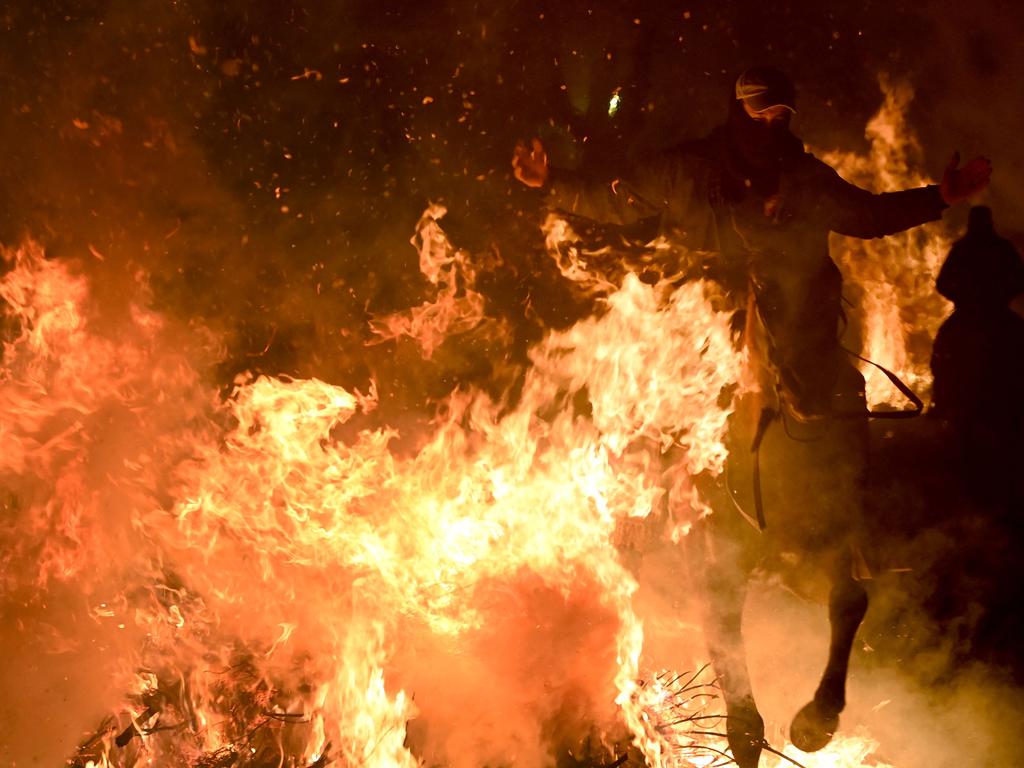 A man rides through the bonfire. Picture: Pierre-Philippe Marcou/AFP