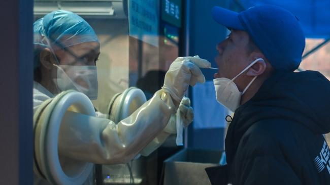 A health worker tests a man for COVID-19 at a hospital in Wuhan, China. Picture: AFP