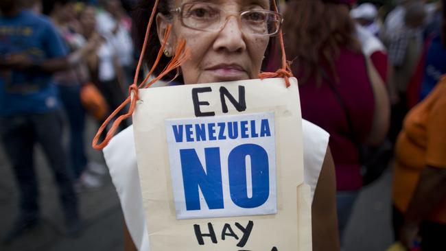 Protester Beatriz Silva, 74, wears a sign that reads in Spanish: “In Venezuela, there’s nothing”. Picture: Ariana Cubillos/AP