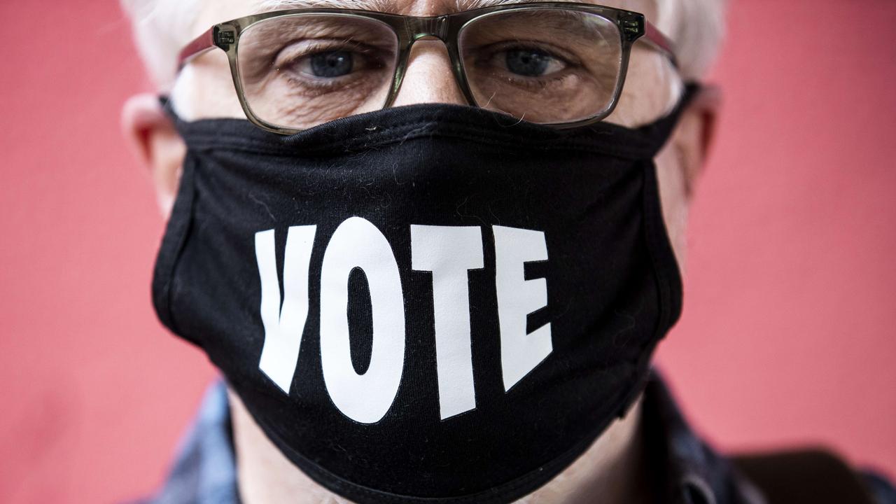 SAN FRANCISCO, CA - NOVEMBER 03: John Moran poses for a photo while wearing a mask that reads "VOTE" after casting a ballot at a polling station at Miette Patisserie on November 3, 2020 in San Francisco, California. After a record-breaking early voting turnout, Americans head to the polls on the last day to cast their votes for incumbent U.S. President Donald Trump or Democratic nominee Joe Biden in the 2020 presidential election.   Stephen Lam/Getty Images/AFP == FOR NEWSPAPERS, INTERNET, TELCOS & TELEVISION USE ONLY ==