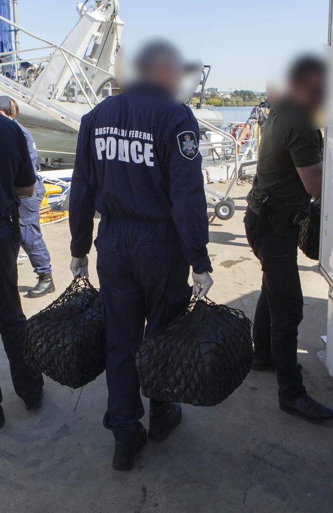 A Federal Police officer carries evidence allegedly linked to the case.