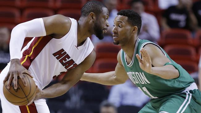 Miami Heat guard Dwyane Wade looks for an open teammate past Boston Celtics guard Evan Turner.