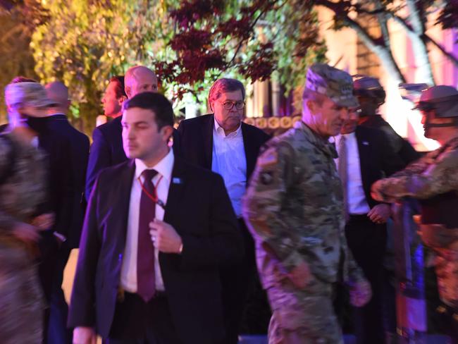 US Attorney-General William Barr, centre, white shirt, walks around downtown Washington on Monday night. Picture: AFP