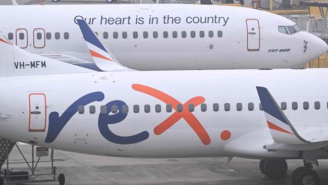 Rex Airlines Boeing 737 planes lay idle on the tarmac at Melbourne's Tullamarine Airport on July 31, 2024. The Australian regional airline Rex cancelled flights as it entered voluntary administration on July 31, leaving the fate of the country's third-largest carrier in serious doubt. (Photo by William WEST / AFP)