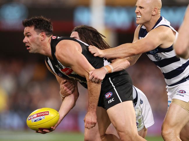 Levi Greenwood of the Magpies tackled by Gary Ablett and Gryan Miers of the Cats. Pic: Michael Klein