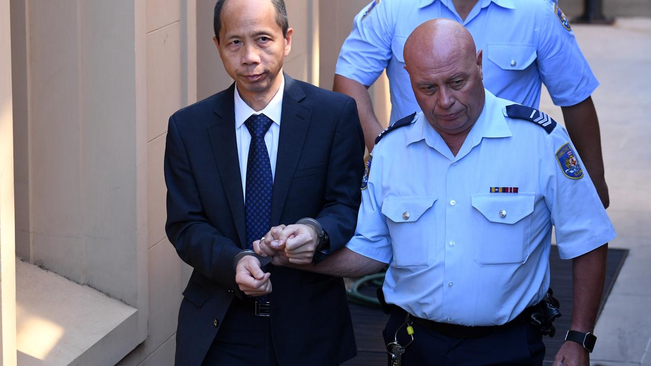 Robert Xie (left) is escorted to a prison transport vehicle after one of his trials for five murders. Picture: Paul Miller.