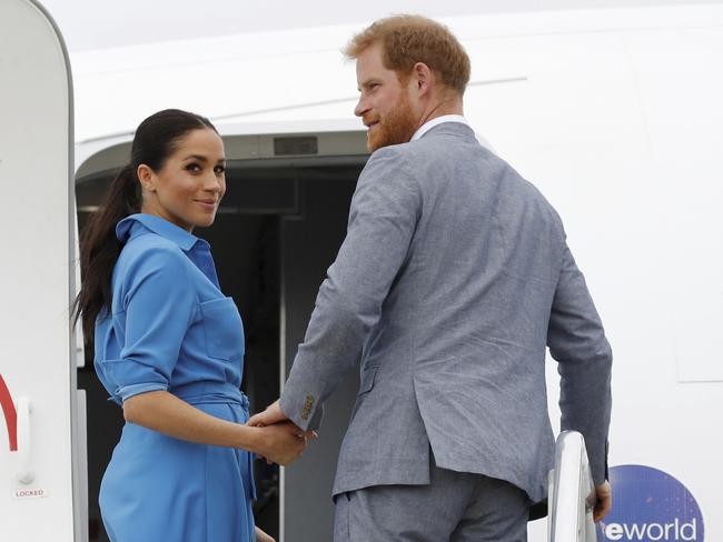 Britain's Prince Harry and Meghan, Duchess of Sussex wave before departing from Fua'amotu International Airport, Tonga, Friday, Oct. 26, 2018. Prince Harry and his wife Meghan are on day 11 of their 16-day tour of Australia and the South Pacific. (Phil Nobel/Pool Photo via AP)