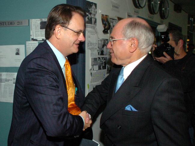 The handshake that swung an election: Prime Minister John Howard and Opposition Leader Mark Latham cross paths in a radio station in Sydney. Picture: John Feder