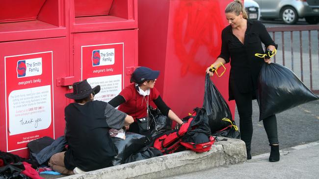 But excited locals pounced on the bags and started going through the items before Falkiner could even put them into the bin. Picture: DIIMEX