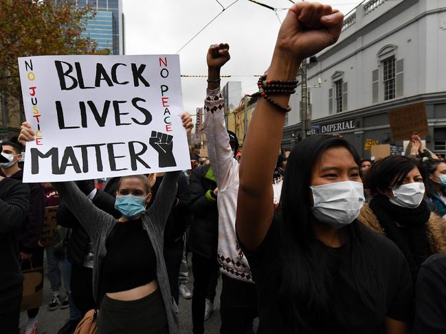 Protesters are seen during a Black Lives Matter rally in Melbourne, Saturday, June 6, 2020. The rally is in solidarity with the US protests over the killing of George Floyd, and is also calling for an end to Aboriginal deaths in police custody. (AAP Image/James Ross) NO ARCHIVING