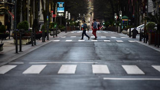 Pedestrians pass an empty Gran Via street, in Bilbao, northern Spain on Saturday.