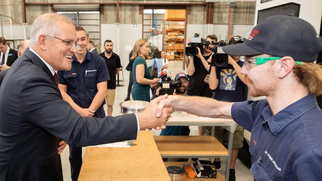 Scott Morrison shakes hands with apprentice Jack Davey, 20, in South Nowra on the NSW south coast where the Black Summer bushfires raged. Picture: Jason Edwards