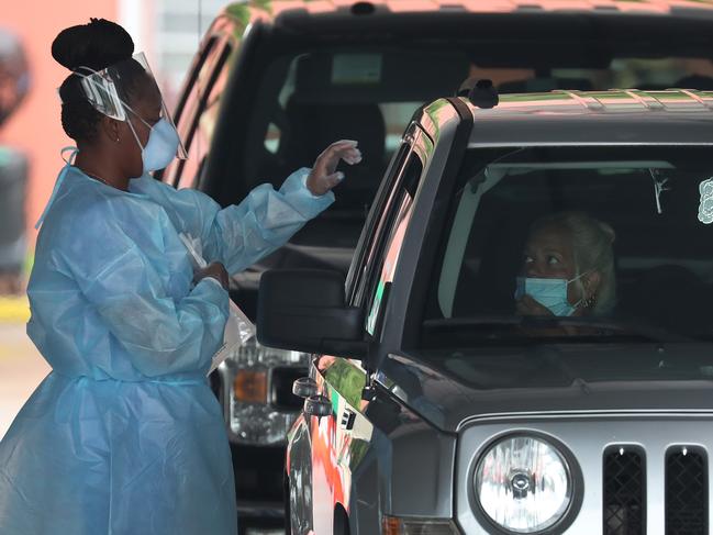 MIAMI, FLORIDA - JULY 23: A health care worker directs a person to use a nasal swab for a self administered test at the new federally funded COVID-19 testing site at the Miami-Dade County Auditorium on July 23, 2020 in Miami, Florida. U.S. Surgeon Jerome M. Adams visited the site, as the state of Florida experiences a spike in coronavirus cases, to encourage people to wear a mask and take other precautions to fight the pandemic.   Joe Raedle/Getty Images/AFP == FOR NEWSPAPERS, INTERNET, TELCOS & TELEVISION USE ONLY ==