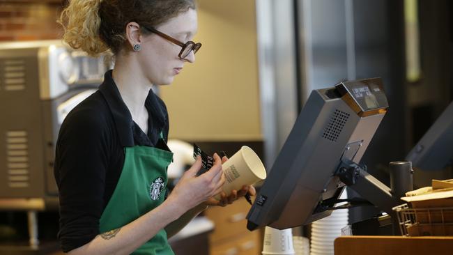 Holly Ainslie, a barista at a Starbucks store in Seattle, writes on a cup for an iced drink. The #RaceTogether campaign was an effort to raise awareness and discussion of race relations.