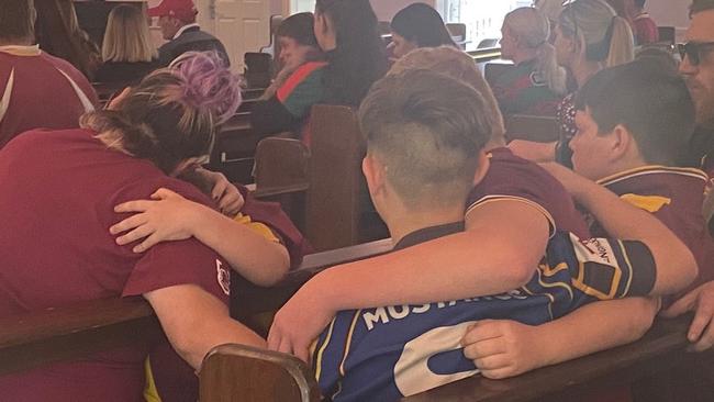 Friends and family comfort each other at Xavier “Dude” Webb’s funeral in Gympie on Friday.