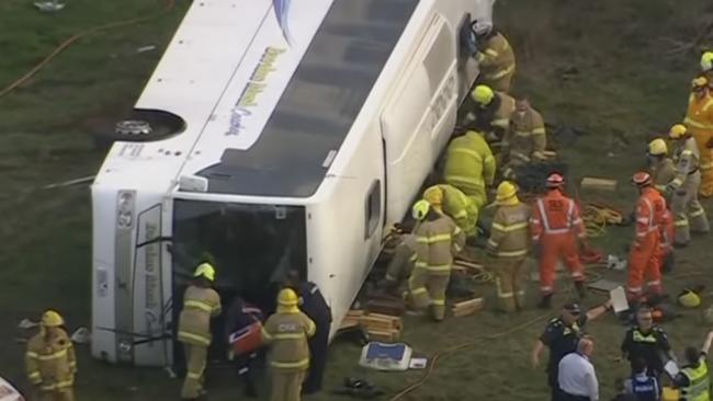 Emergency crews attempt to remove schoolchildren from the wreckage after a school bus rolled in Eynesbury, West of Melbourne. Picture: 7 News