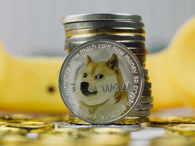Digital currency physical metal dogecoin coin. Yellow phone communication concept.  Picture: istock